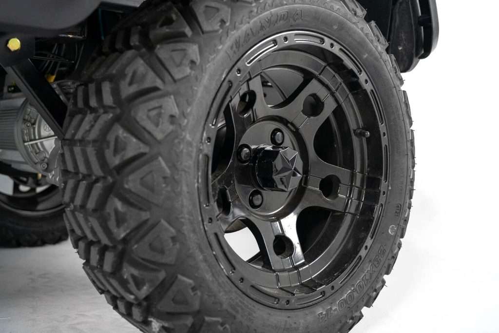 Close-up of a rugged off-road tire and black alloy wheel.