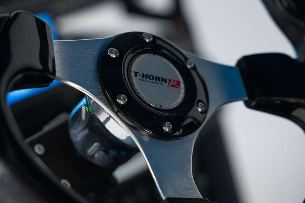 Close-up of a steering wheel with "MOMO" logo in the center.