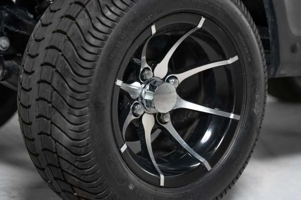 Close-up of a stylish black car tire with silver and black alloy rim.
