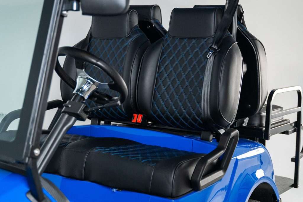 Blue vehicle interior with black diamond-stitched seats and steering wheel.