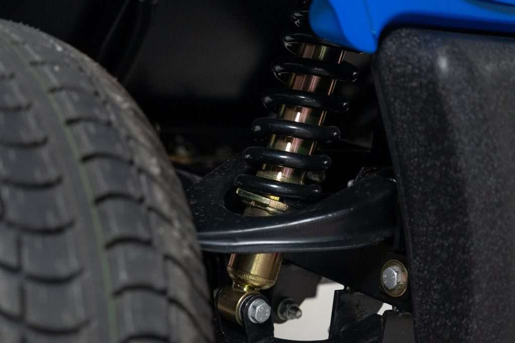Close-up of a vehicle suspension spring and tire.