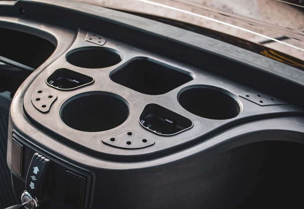 Close-up of a car's dashboard with empty slots and cup holders.