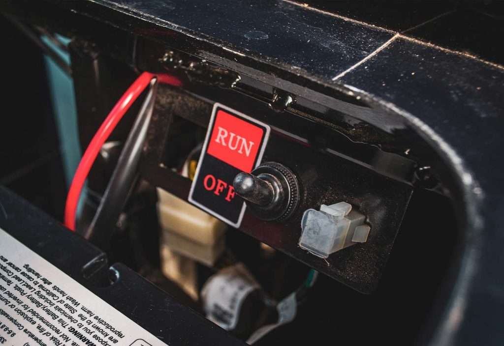 Close-up of a red toggle switch labeled 'RUN' and 'OFF' on an electrical device.