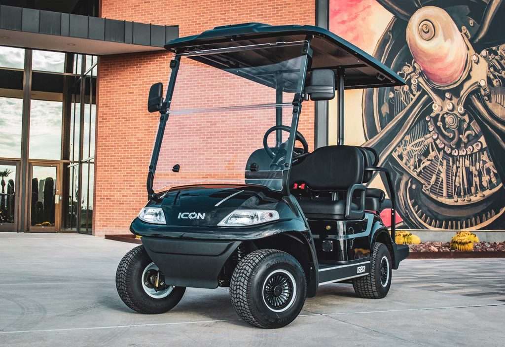 A black golf cart parked outdoors near a building.