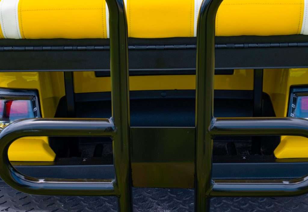 Close-up of a yellow school bus door with black metal bars.