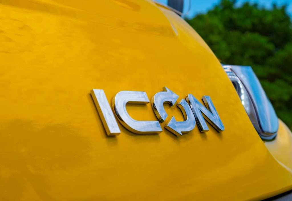 Close-up of a yellow vehicle with the word 'ICON' in silver letters.