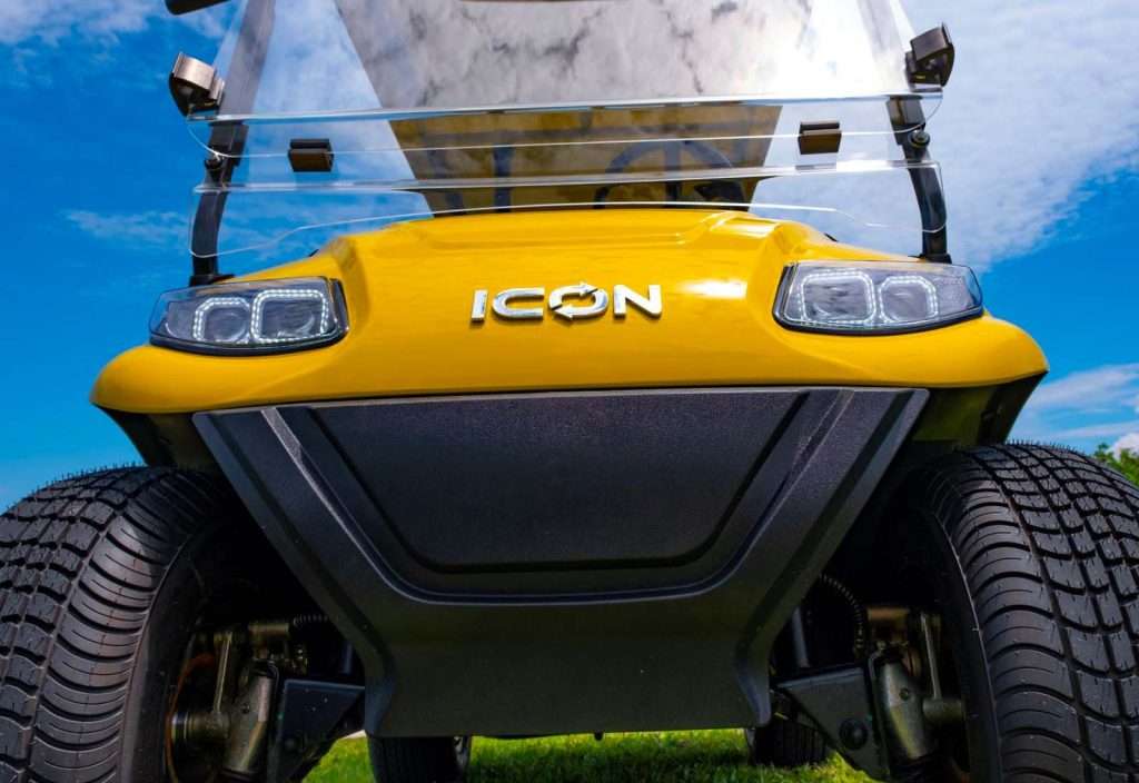 Close-up of a yellow ICON electric vehicle's rear with a clear spoiler.