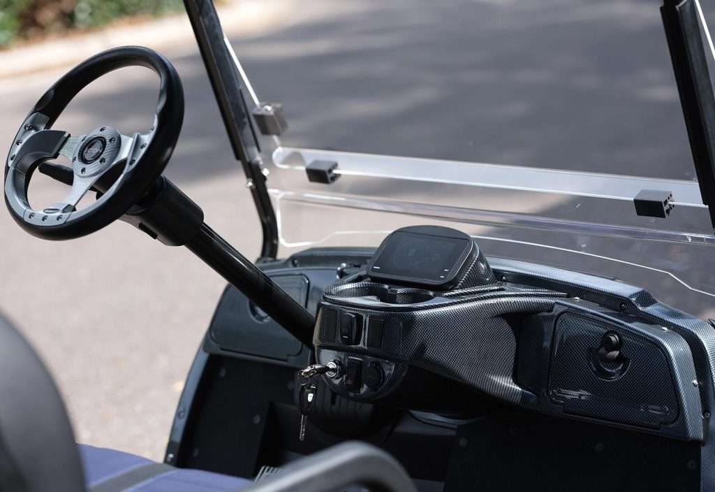 Close-up of a golf cart dashboard with steering wheel and controls.