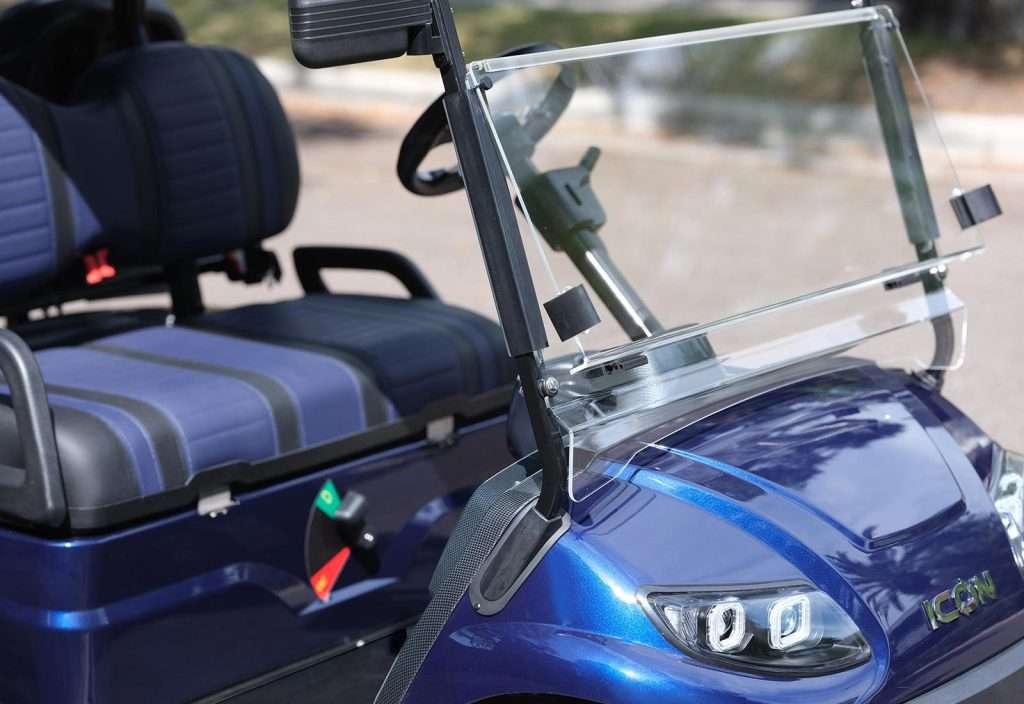 Close-up of a blue golf cart's front seat and windshield.