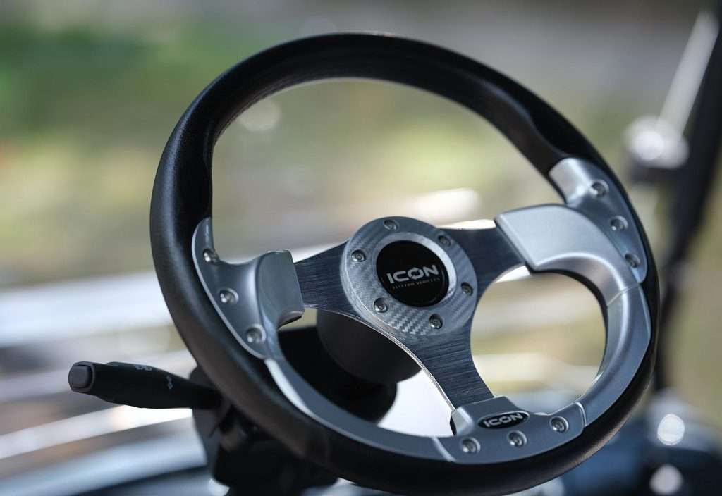 Close-up of a sporty car steering wheel with a sleek design.