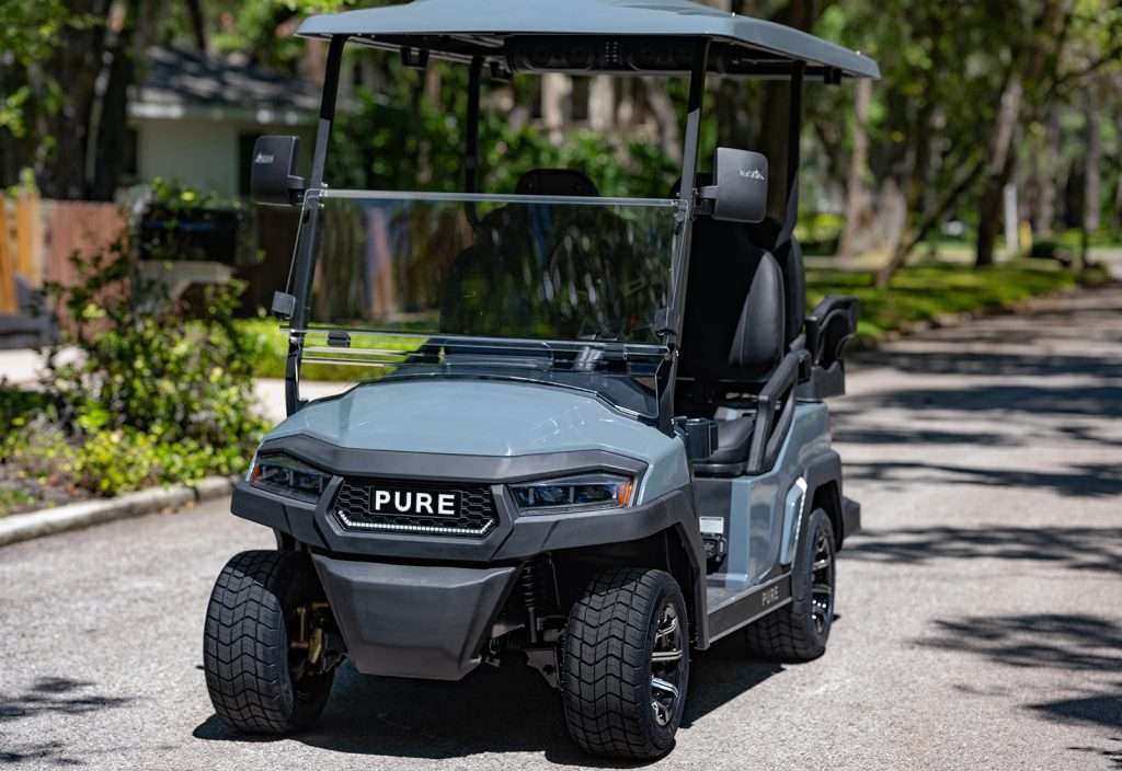 A black PURE utility vehicle parked on a sunny pathway.