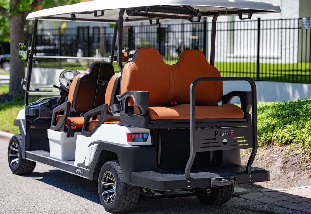 A golf cart with brown cushioned seats parked outdoors.