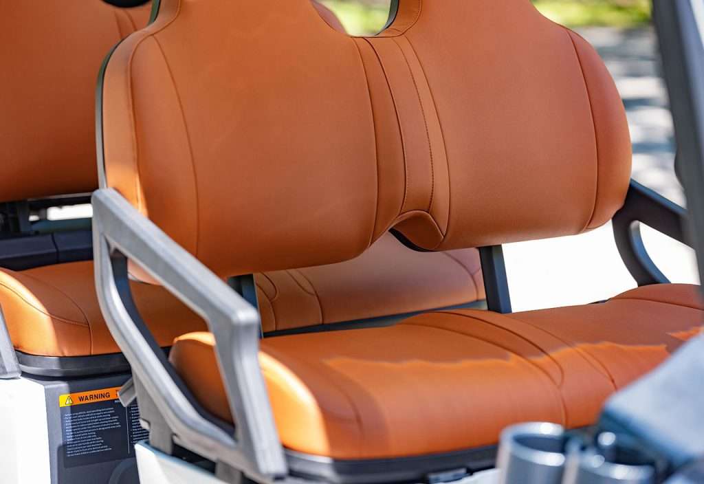 Close-up of an ergonomic brown seat with armrests.