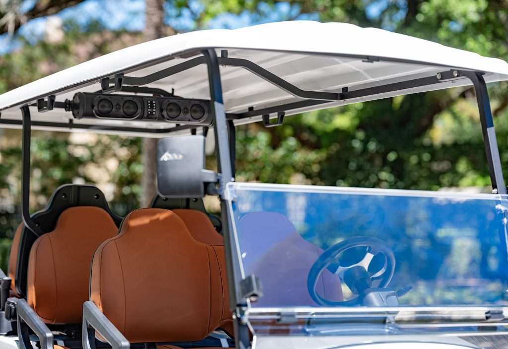 A close-up of a golf cart with brown seats and a white roof.