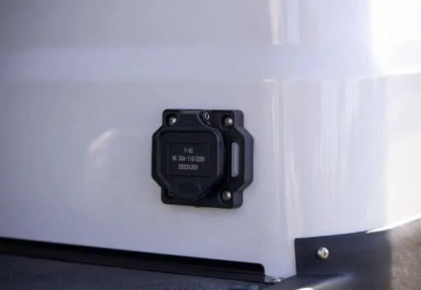 A close-up of a black electronic sensor mounted on a white surface.