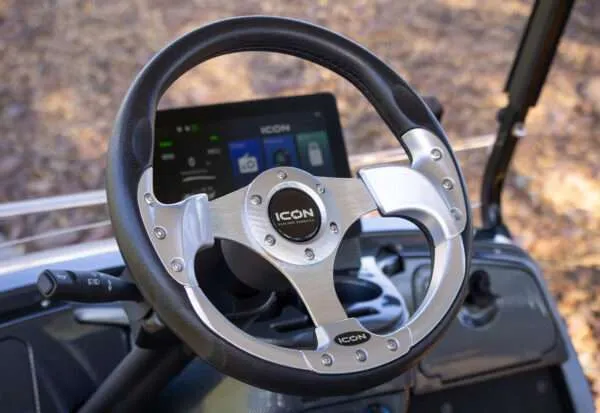 Steering wheel with a mounted smartphone showing a navigation app.