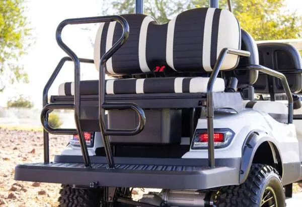 Back view of a golf cart with black cushioned seats and safety bars.