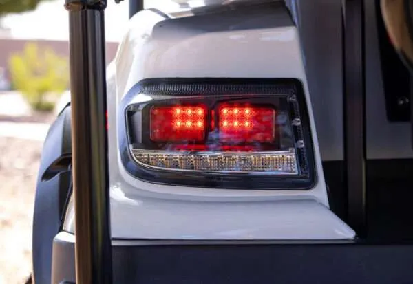 Close-up of a vehicle's illuminated red rear light at night.