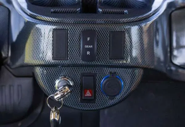 Car ignition with key inserted and dashboard controls shown.