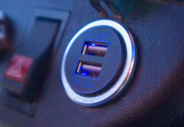 Close-up of a dual USB charging port with blue LED light.