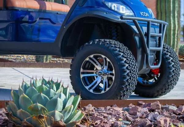 Close-up of a rugged off-road tire and wheel on a blue vehicle.
