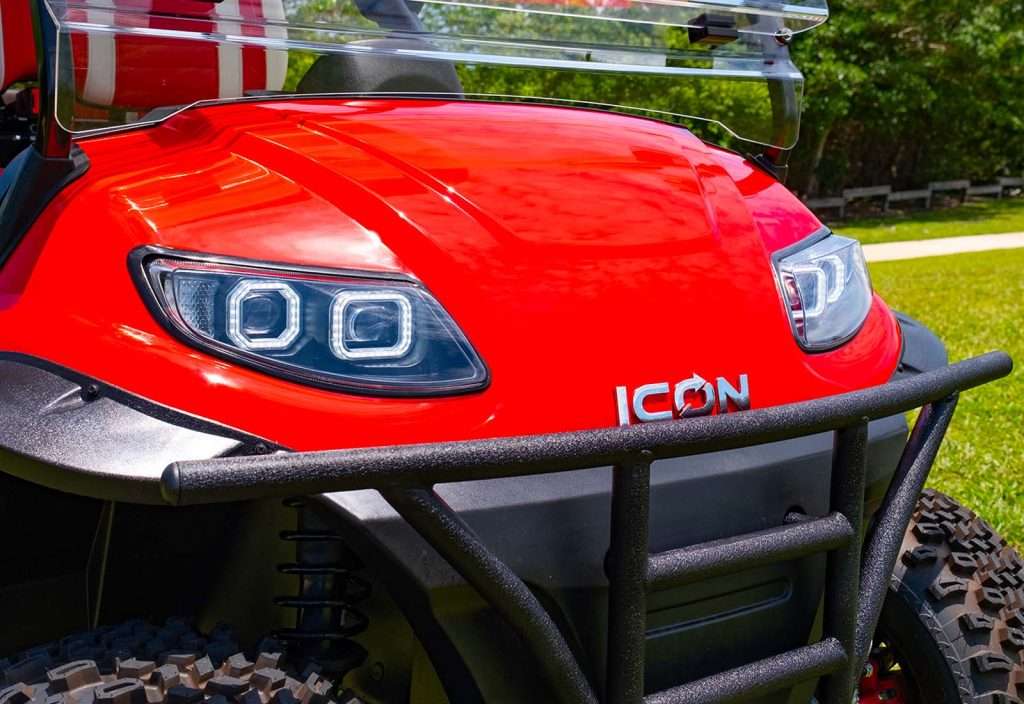 Close-up of a red ICON electric vehicle front with distinctive headlights.