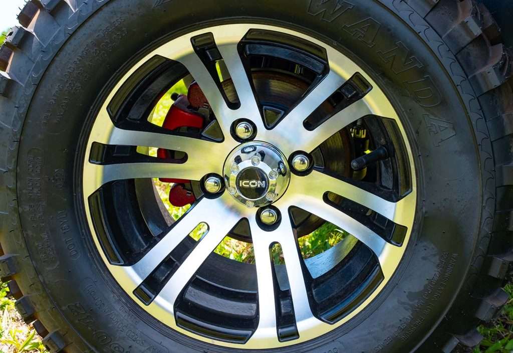 Close-up of a car wheel with a shiny alloy rim and visible brake caliper.