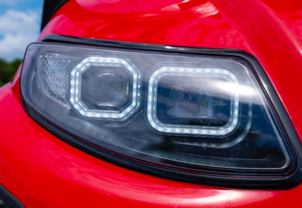 Close-up of a modern car's LED headlight on red body.