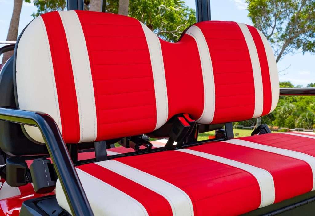 Close-up of red and white striped cushioned seats on a golf cart.