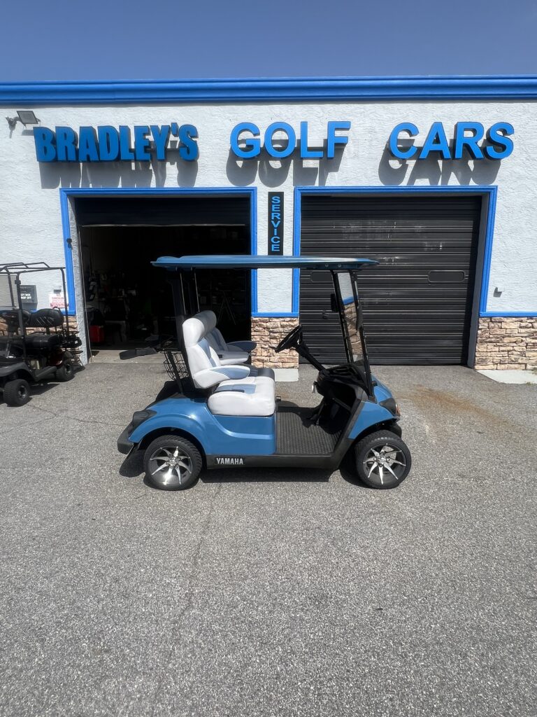 Blue Yamaha golf cart outside golf car shop