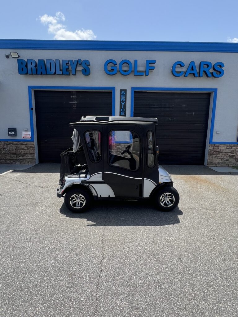 Covered golf cart parked in front of shop